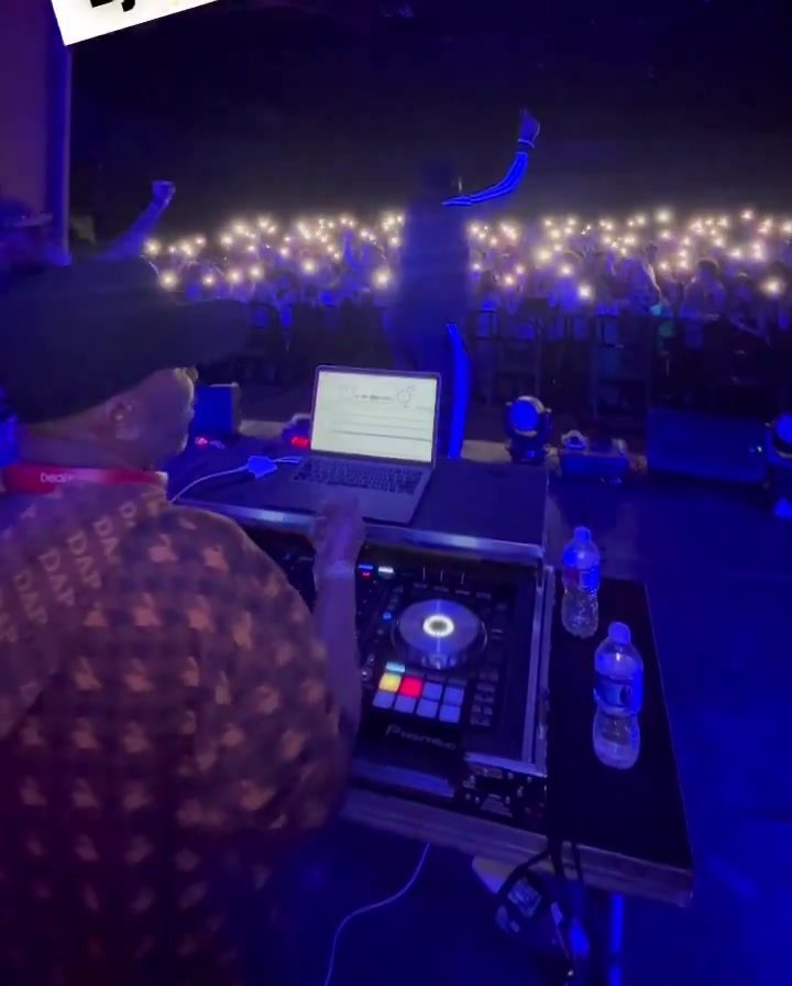 DJ booth view of a concert crowd with phone lights during the Desiigner show